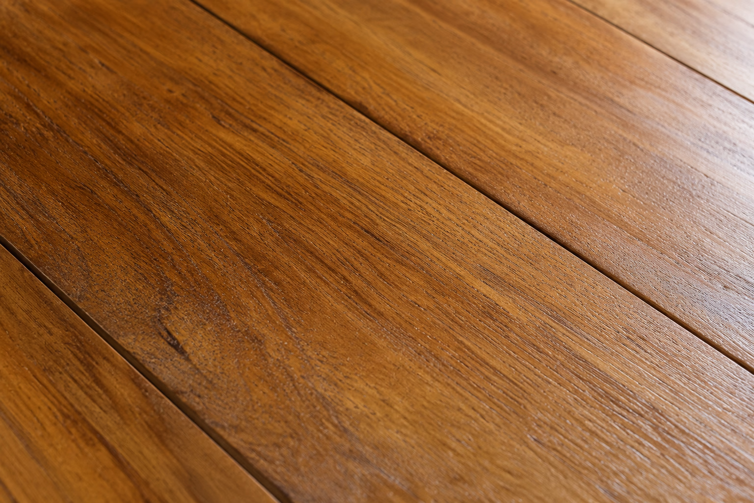Close-up macro texture of solid teak wood flooring showing natural grain and oil content